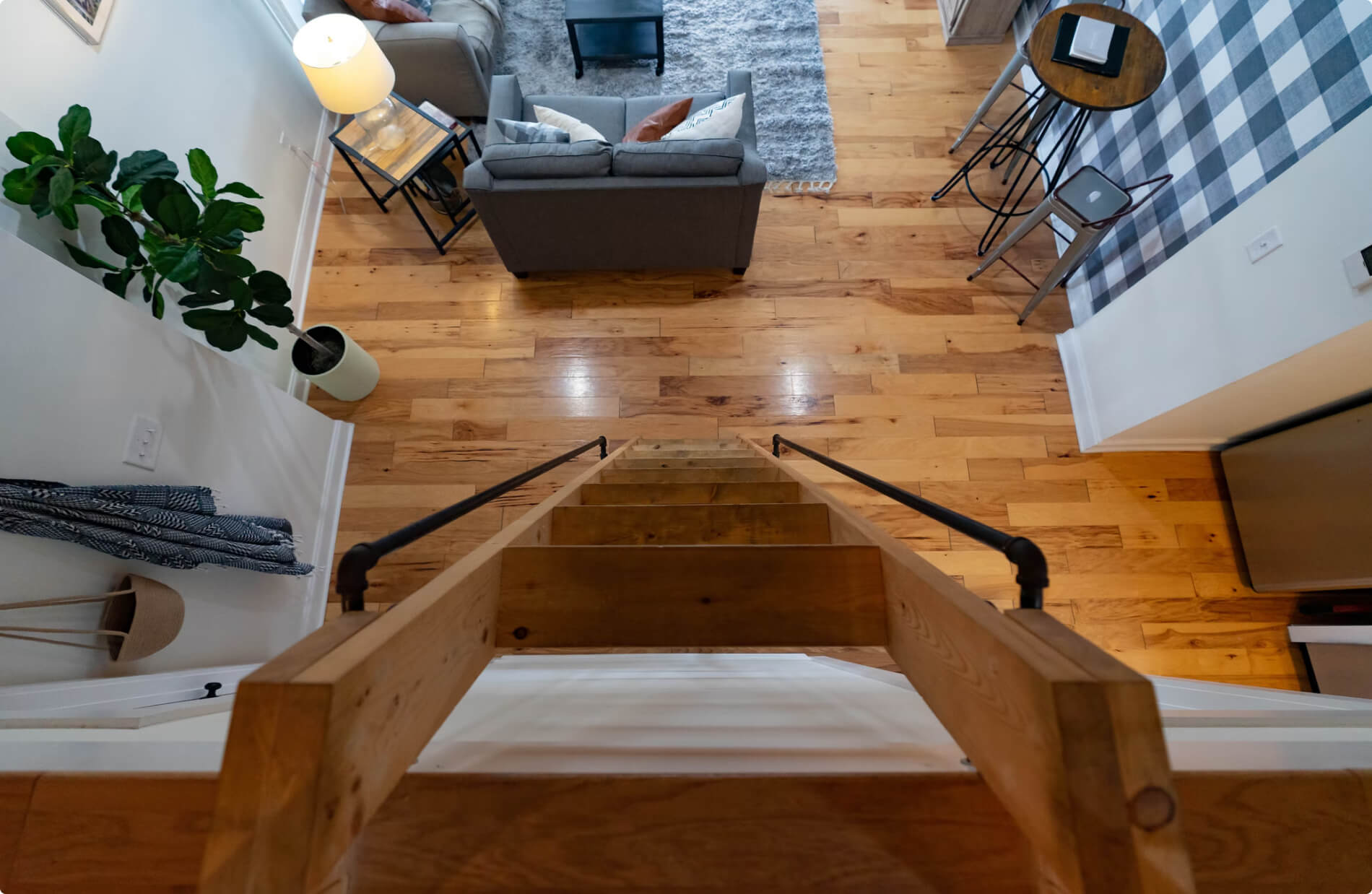 ladder view going down to living room with wood flooring